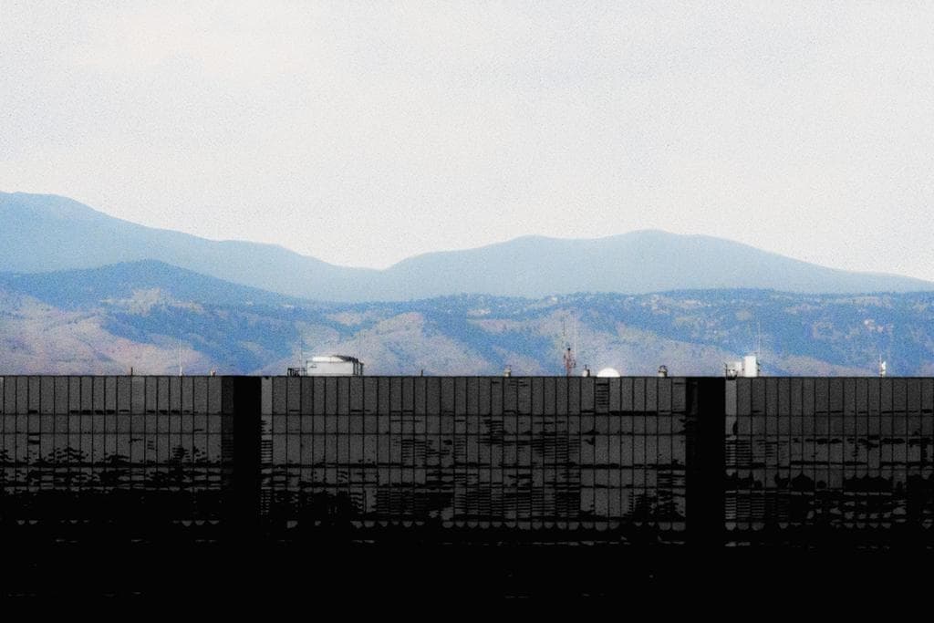 Mountain range with a black building creating a horizon in the foreground